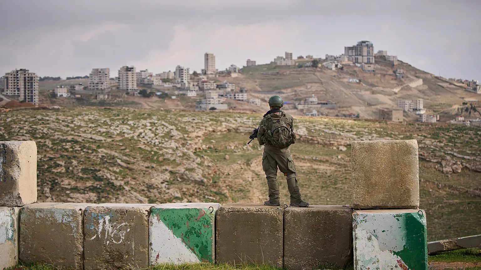 An Israeli soldier stands guard during the inauguration ceremony for the newly legalized Jewish settlement of Yatziv, near the Palestinian town of Beit Sahour, West Bank