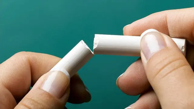 Dos manos con una tiza partida