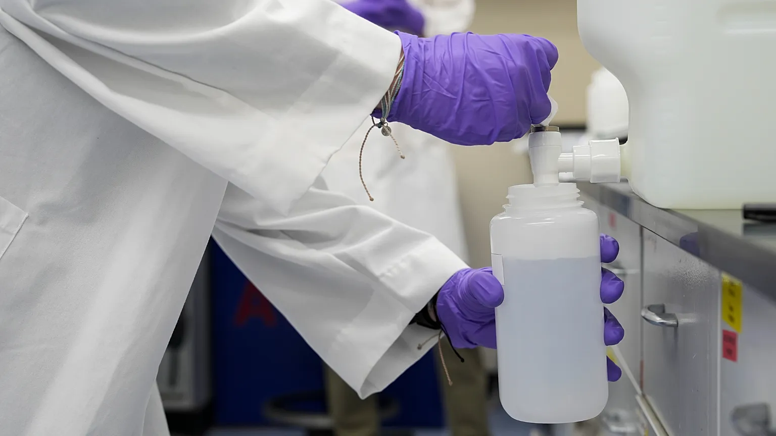 Logan Feeney pours a PFAS water sample into a container for research, Wednesday, April 10, 2024, at a U.S. Environmental Protection Agency lab in Cincinnati.