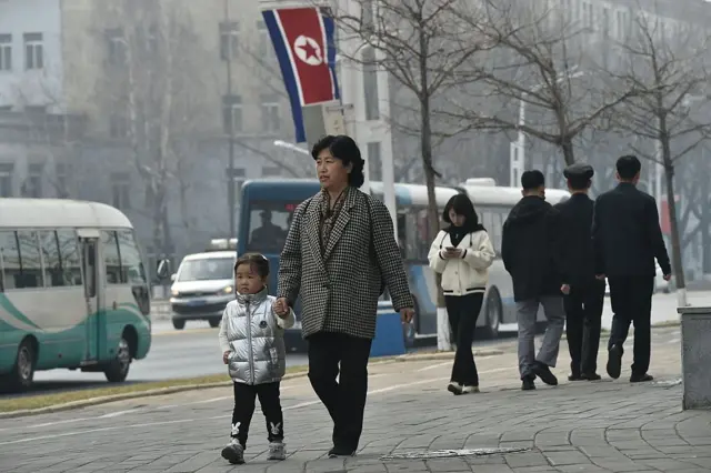 Personas y vehículos transitan por una calle de Pyongyang.
