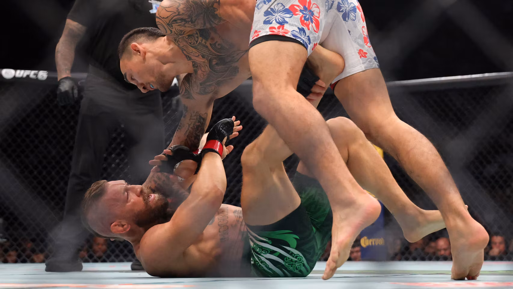 Conor McGregor, en el suelo, encajando los golpes de Max Holloway.