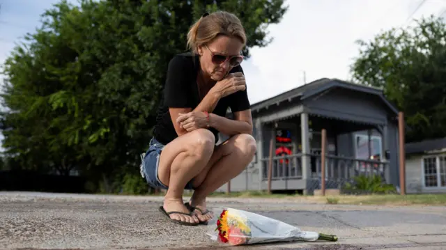 Rhonda Smith, vecina de Magnolia Park, coloca flores junto al lugar donde falleció Lorenzo Salgado Araujo.