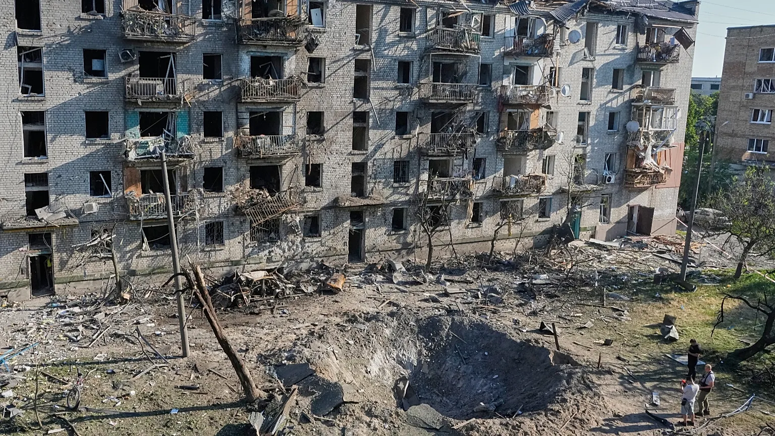 People look at the site of a Russian missile strike that hit a residential building in Kyiv, 2 July, 2026