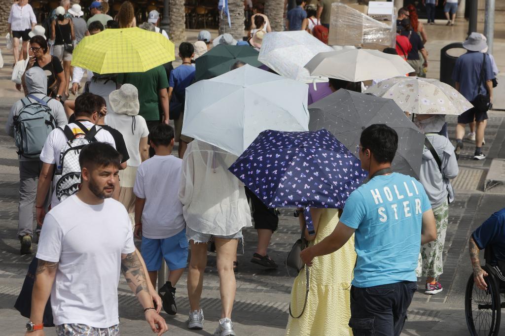 La gente se protege del sol con paraguas en Alicante.