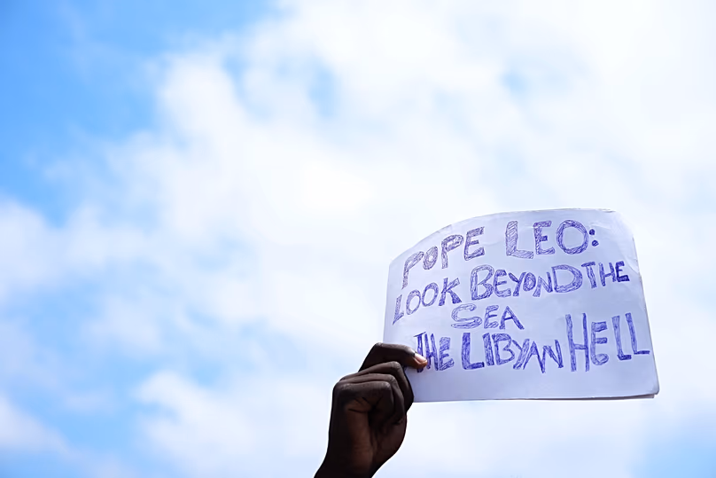 A sign urges the Pope to look beyond the sea, towards the 'hell in Libya'