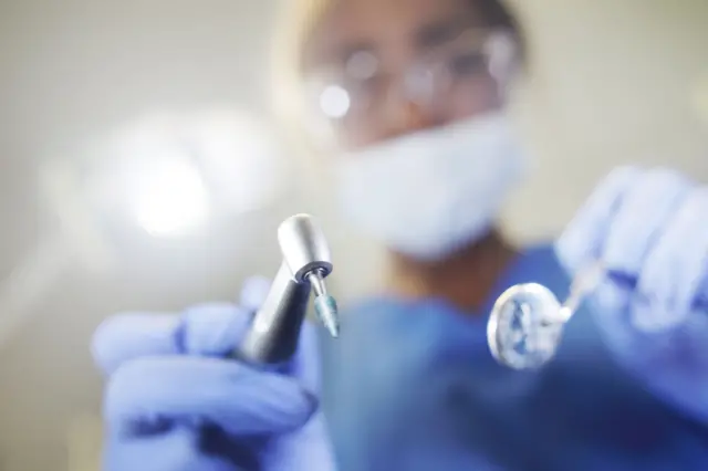 Un dentista sostiene sus instrumentos de trabajo.