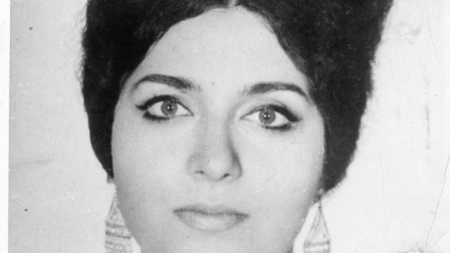 Alejandra Jáidar ve a la cámara. Su cabello es oscuro y sus ojos son claros. Tiene unos zarcillos largos y lleva el cabello recogido