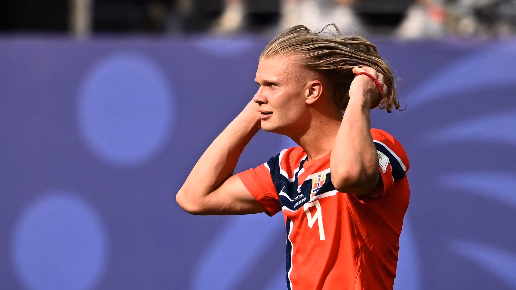 Erling Haaland recogiendo su melena en mitad de un partido.