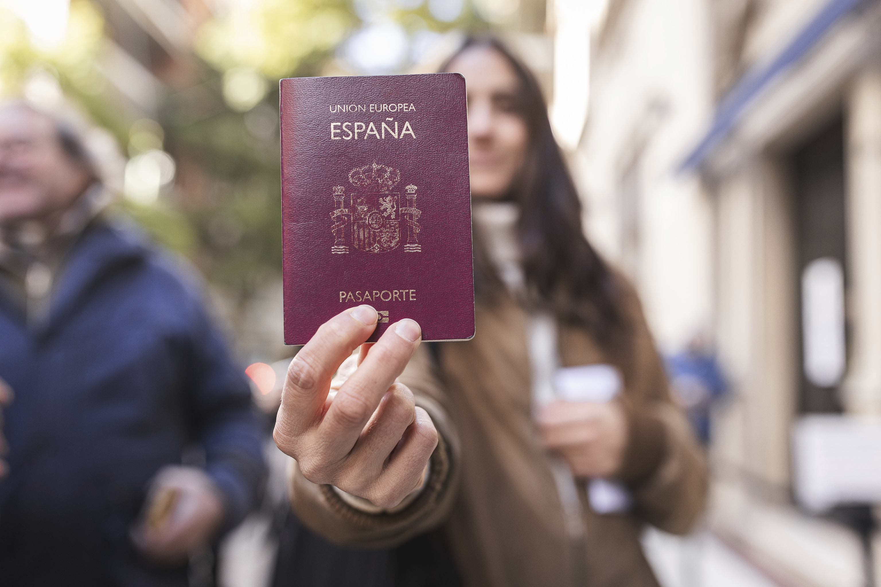 Una mujer muestra su pasaporte español en el Consulado de España en Buenos Aires