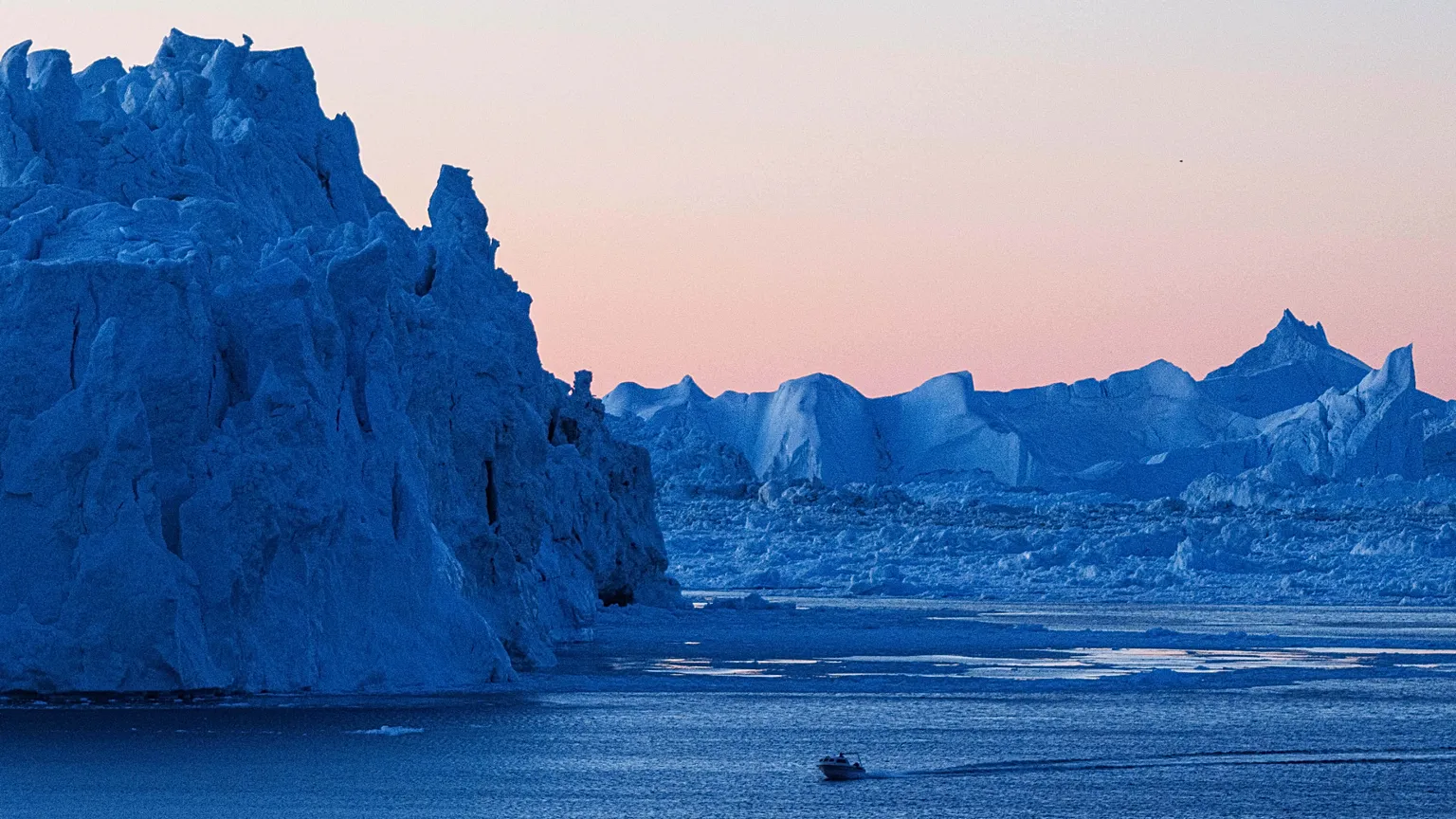FILE -A boat rides in front of an iceberg at Disko Bay near Ilulissat, Greenland, on 28 Jan. 2026. (AP Photo/Evgeniy Maloletka, File)