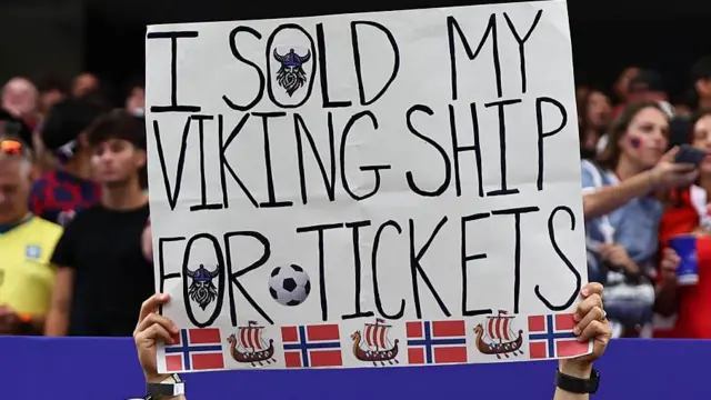 Un aficionado noruego sostiene un cartel que dice que vendió su barco vikingo para comprar entradas para el partido durante la Copa Mundial de la FIFA 2026.