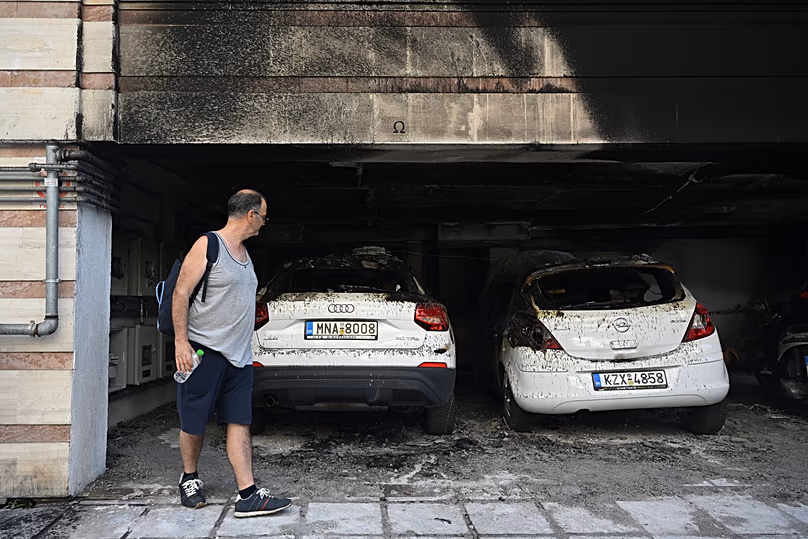 A man looks at burned vehicles following firebomb attacks that apparently targeted members of Greece's governing conservative New Democracy party in Thessaloniki, 1 July, 2026