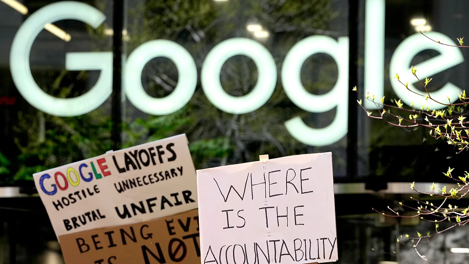 Google employees hold signs during a protest outside Google headquarters in London, 4 April, 2023.