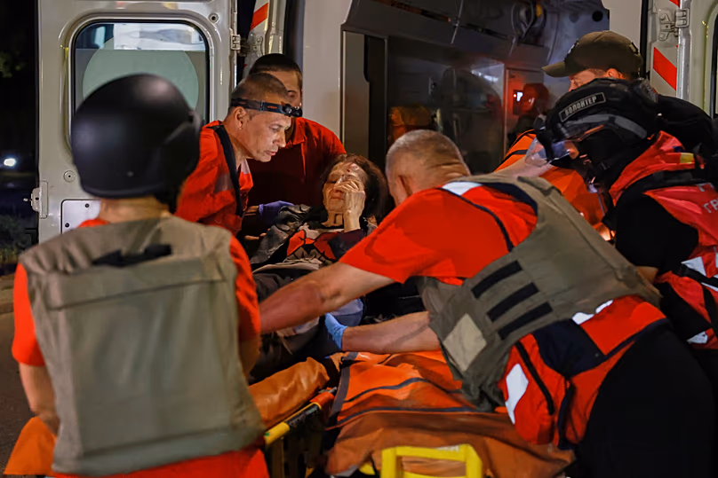 Rescuers evacuate a resident from an apartment building destroyed by a Russian drone attack on Zaporizhzhia, 12 July, 2026