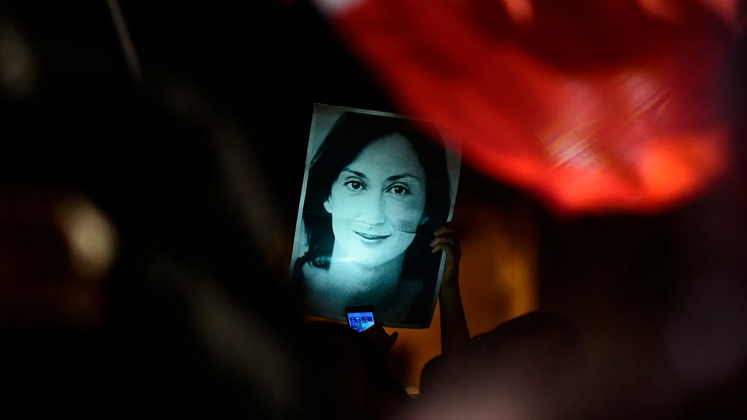 Protesters hold photos during a protest outside the office of the Prime Minster of Malta in Valletta, 29 November, 2019 