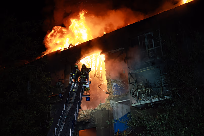 Rescue workers try to put out a fire of a residential building burning after a Russian drone attack on Zaporizhzhia, Ukraine, late Sunday, July 12, 2026.