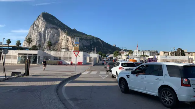 Coches haciendo cola para entrar en Gibraltar desde España, con el Peñón de Gibraltar al fondo.
