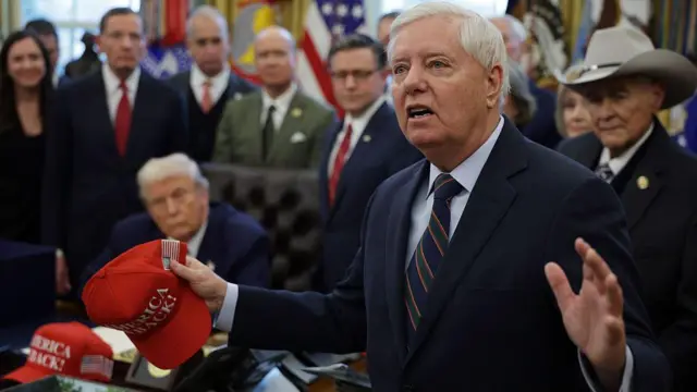 Lindsey Graham pronuncia un discurso durante la firma de un proyecto de ley en el Despacho Oval. El presidente Donald Trump se puede ver al fondo.