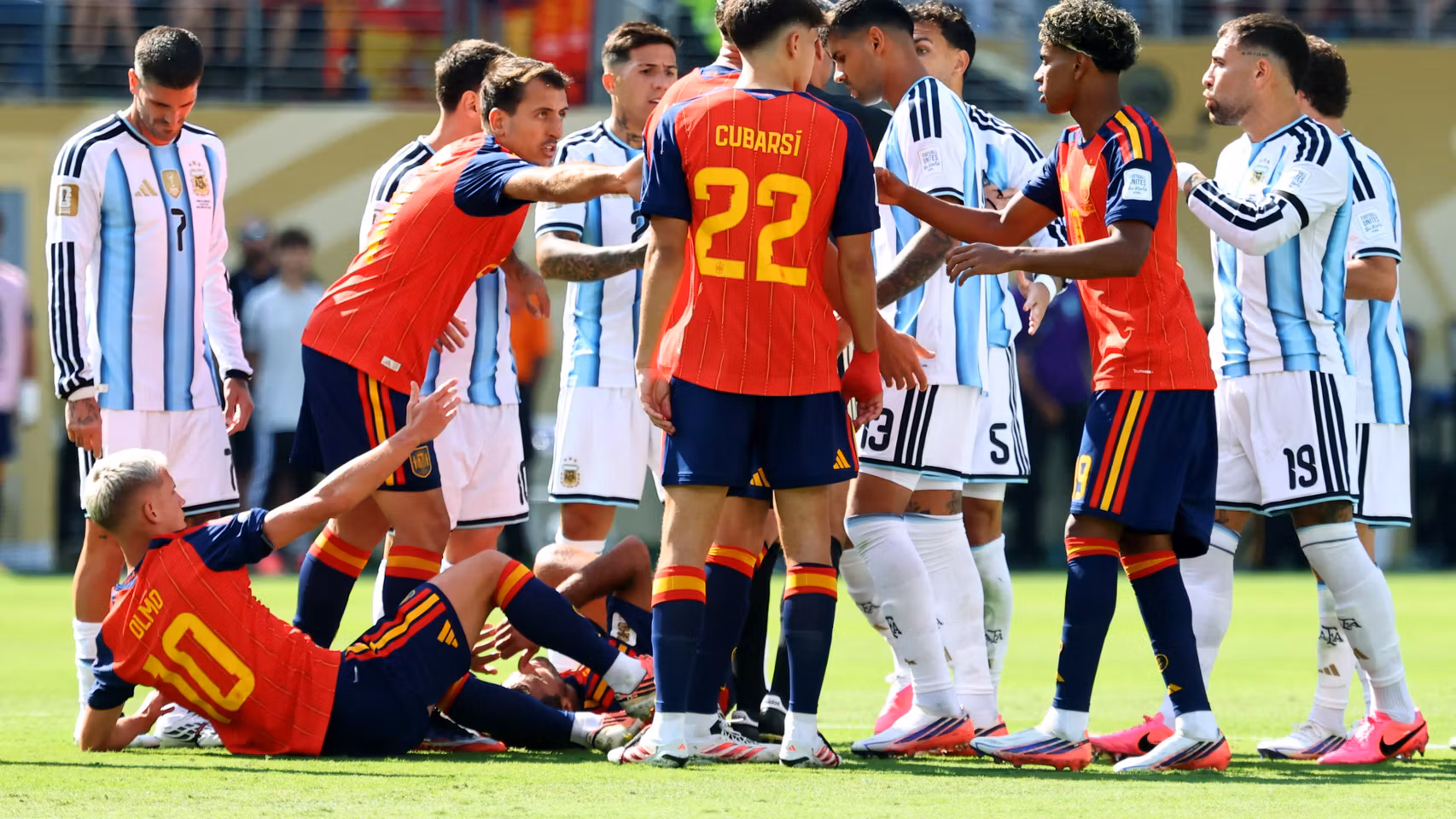 Los jugadores de España y Argentina discuten en el césped.