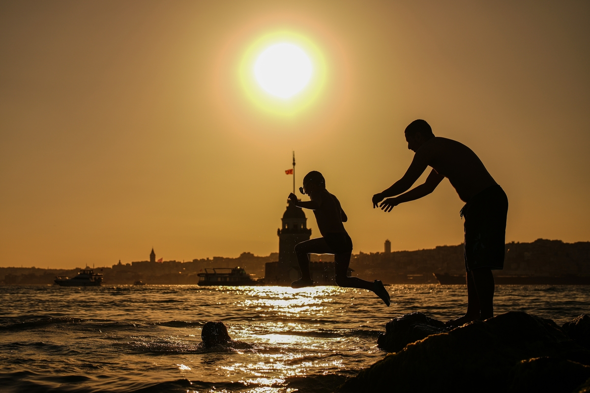Personas saltando al agua por la ola de calor, en una imagen de archivo. (AP Photo/Emrah Gurel)