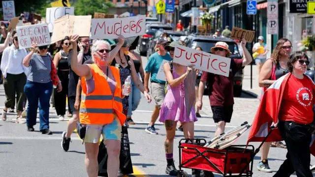Manifestantes con pancartas contra el ICE en Maine