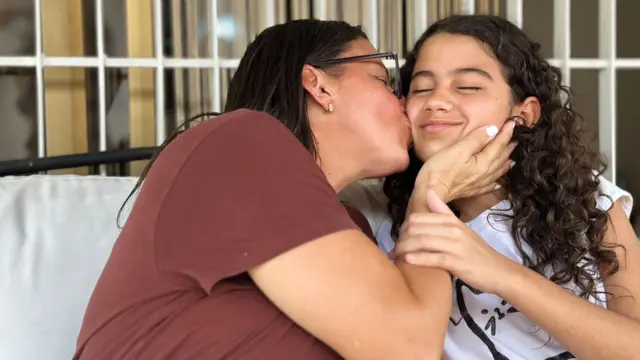 Karina besando en el cachete a su hija, Fabiana.