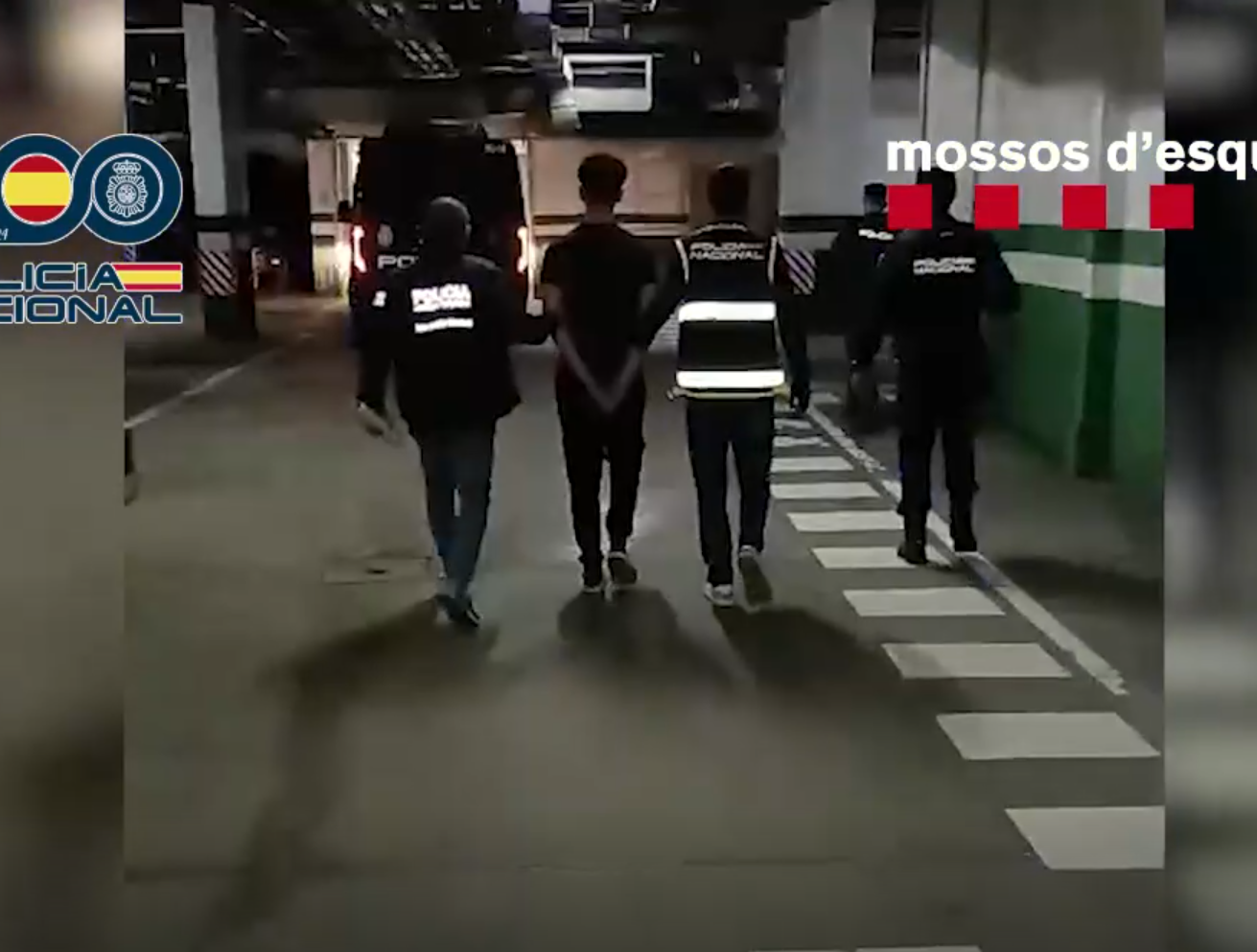 Los agentes escoltan a uno de los detenidos durante el operativo.
