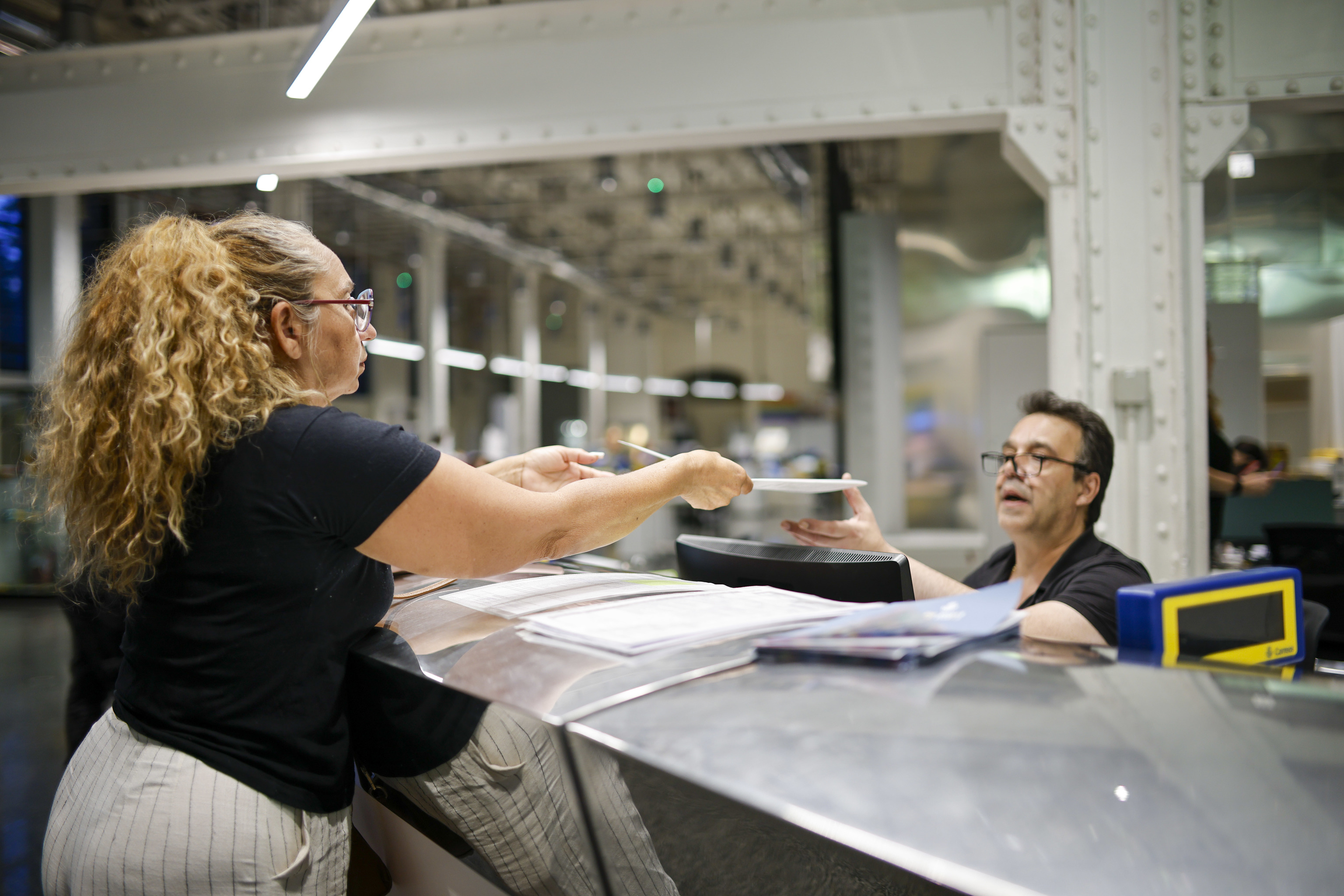 Un funcionario de Correos atiende a una solicitante de la regularización extraordinaria de inmigrantes.