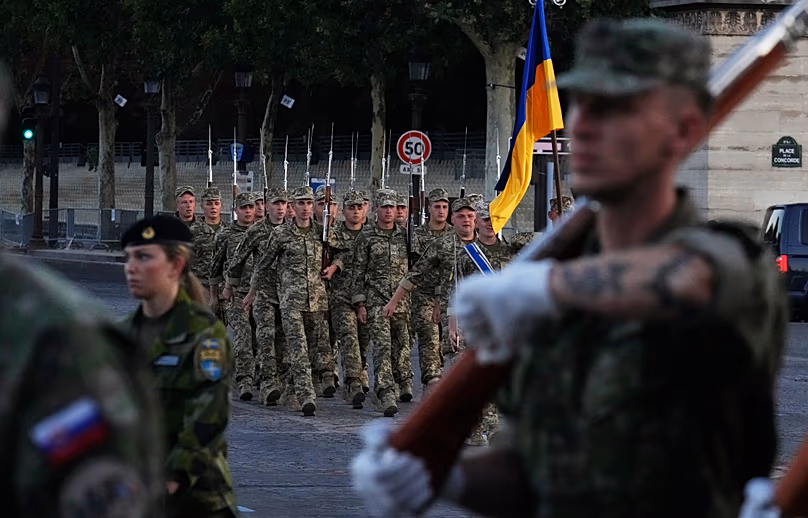 Ukrainian soldiers march with their national flag during a rehearsal for the upcoming 14 July parade, on Thursday 9 July 2026, on the Champs-Élysées in Paris.