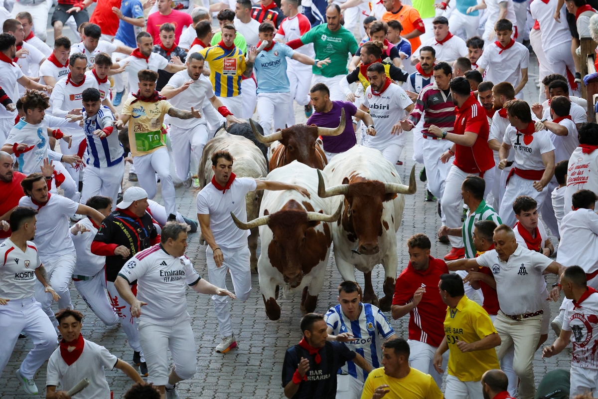 Mozos corren entre los toros en un encierro de los Sanfermines. REUTERS/Pankra Nieto