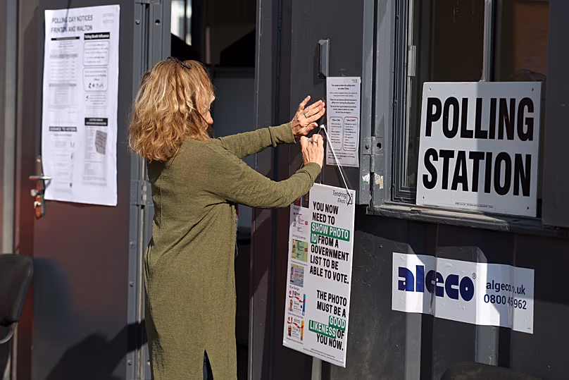 A worker prepares signs at a polling station for local elections in Walton on the Naze, 7 May, 2026 