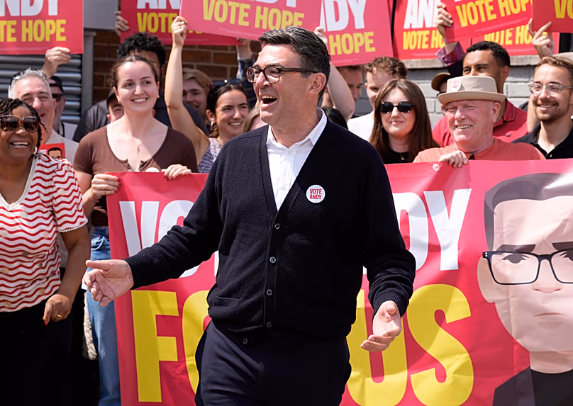 Burnham gestures, surrounded by supporters at the Stubshaw Cross Community and Sports Club as voting is underway in the Makerfield by-election.