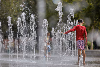 Un niño se refresca en una fuente durante este miércoles. (Ana Escobar/EFE)
