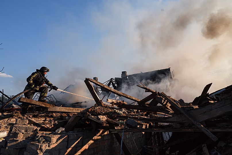 A rescue worker puts out a fire of a house destroyed after a Russian strike on residential neighbourhood in Zaporizhzhia, 30 June, 2026
