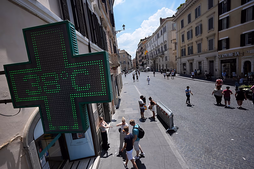 The thermometer of a drugstore shows the temperature of 38 degrees Celsius (100 degrees Fahrenheit) as temperatures reach record highs, in Rome, Wednesday, June 24, 2026. 