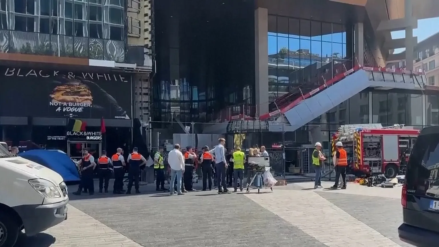 Firefighters and other people outside Oxy Tower building in Brussels, Belgium. 14 July 2026.