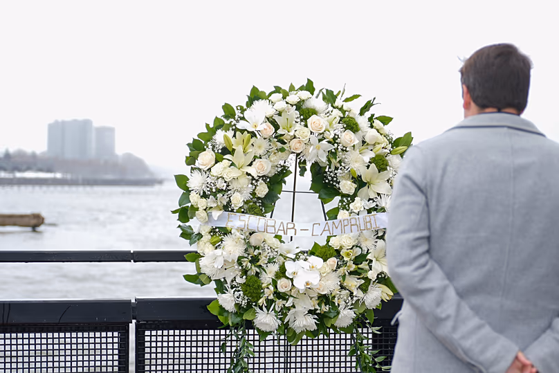 Joan Camprubí Montal, a relative of five of the victims of the Hudson River helicopter crash, stands in front of a memorial wreath in New York on Saturday, 12 April 2025.