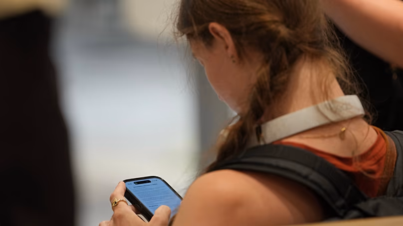 A teenager looks at her mobile phone. (AP Photo/Kin Cheung)