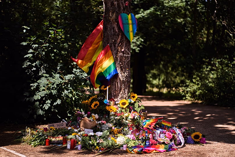 Flowers and rainbow flags placed at a tree in the Tiergarten Park near the scene where a car rammed into people after Saturday's Pride March in Berlin, Germany, July 27, 2026.