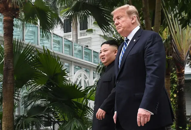 Kim Jong-un camina sonriente a la derecha de Donald Trump en una cumbre en Hanói.