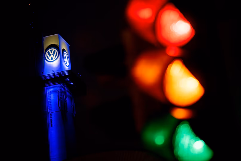 A traffic light shines in front of a Volkswagen logo at the Volkswagen plant in Osnabrück, 29 October, 2024