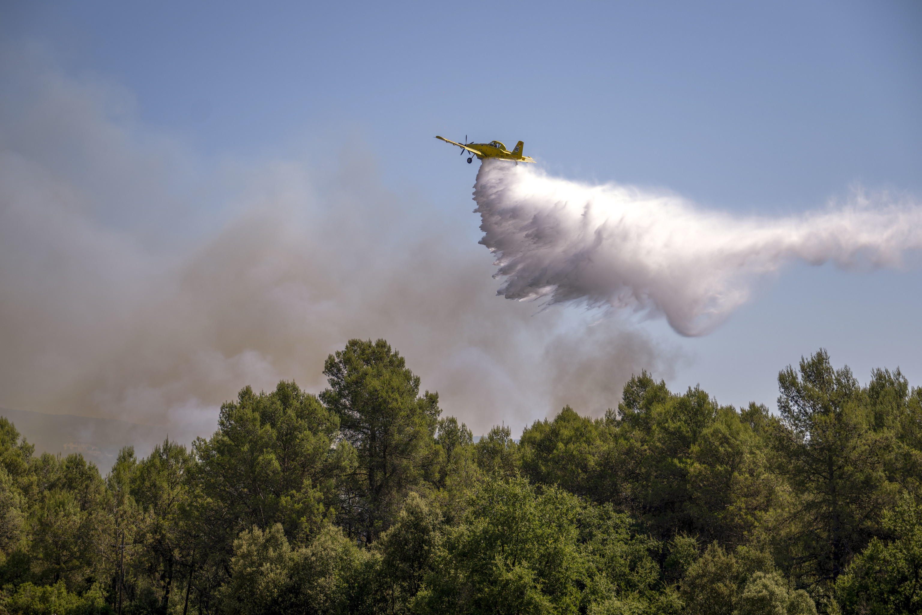 Un avión de los Bomberos actúa en la zona afectada por en incendio en el Pla de Manlleu, en Aiguamúrcia (Tarragona)