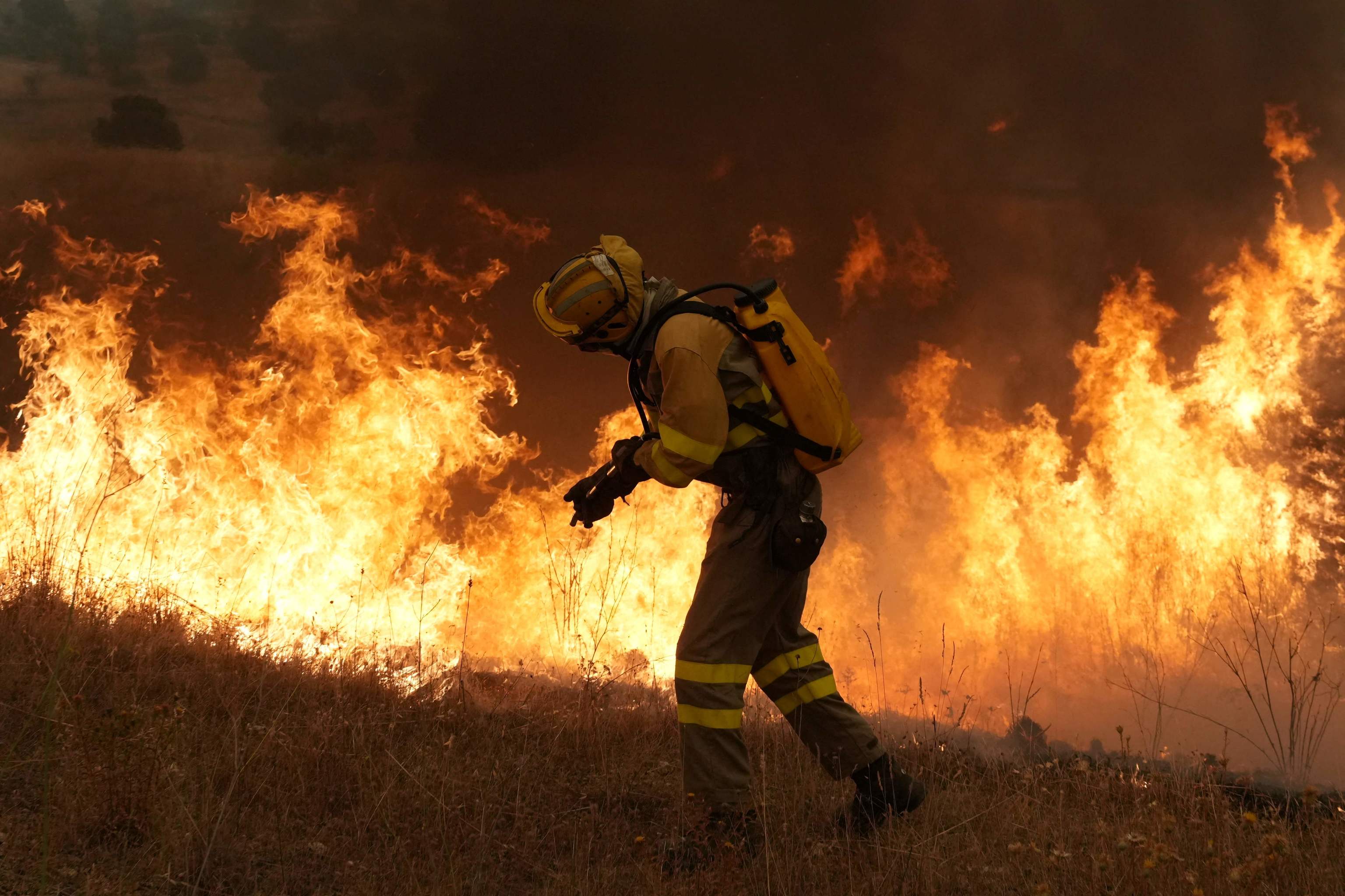 Los bomberos combaten un incendio forestal en la zona de Cebreros, cerca de Ávila. a unos 80 kilómetros al oeste de Madrid.