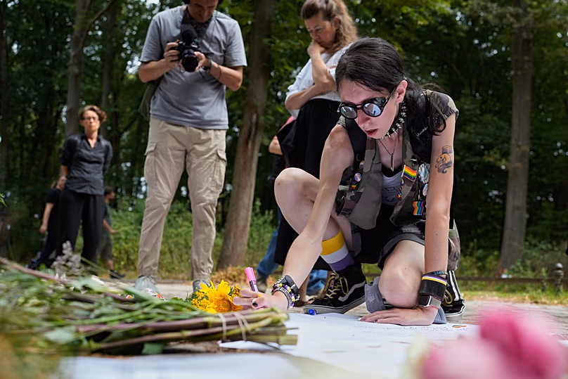 Ashley Schreiber lays flowers near the scene of the attack; a car had ploughed into the crowd at Berlin's CSD, killing one woman and injuring 29 people (c) AP