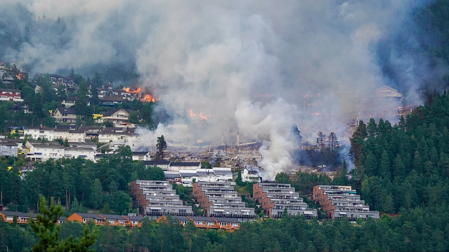 Smoke rises over terraced houses on fire in the Krokstadelva village in Drammen, Norway, Friday. July 17, 2026. (Thomas Fure/NTB Scanpix via AP)
