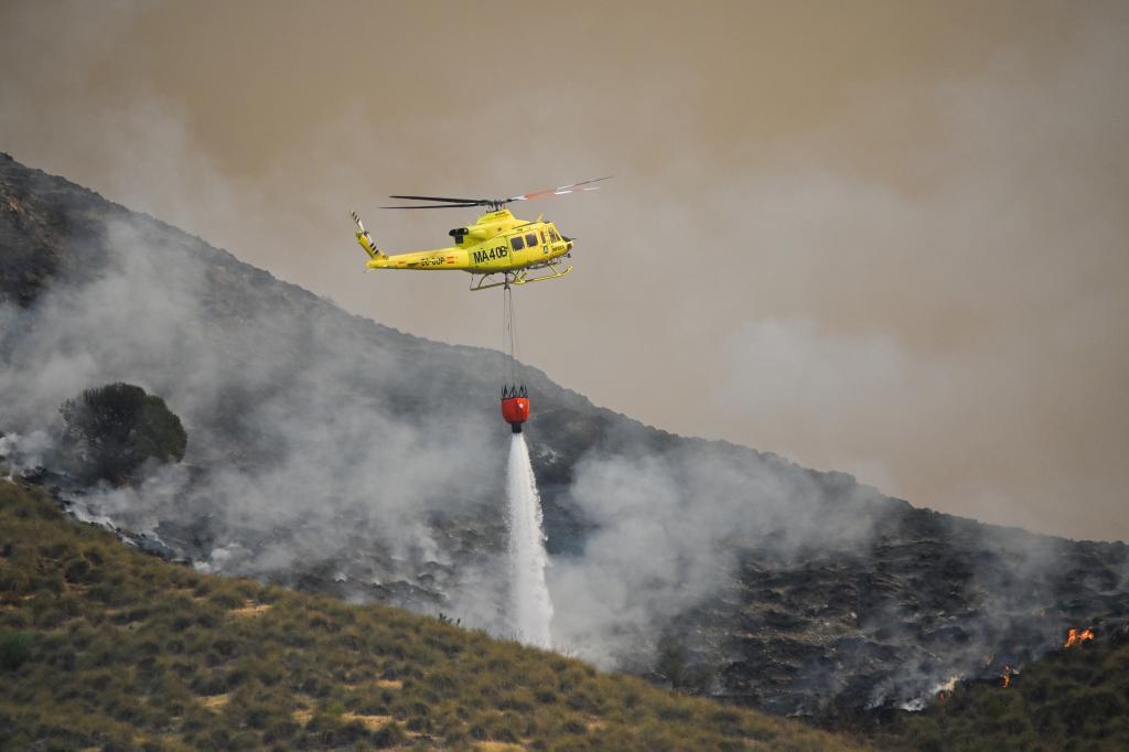 Un helicóptero del servicio de extinción de incendios arroja agua sobre uno de los focos de Los Gallardos.