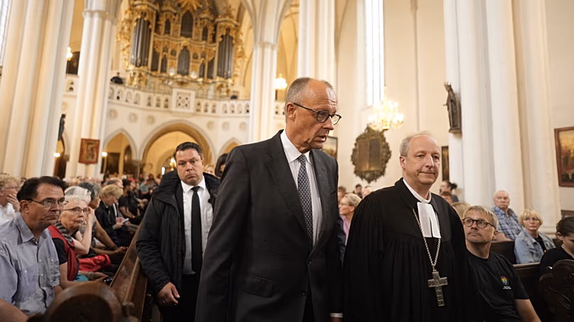 Merz meets Protestant bishop Christian Staeblein for a vigil at St Mary's Church in Berlin on 26 July 2026
