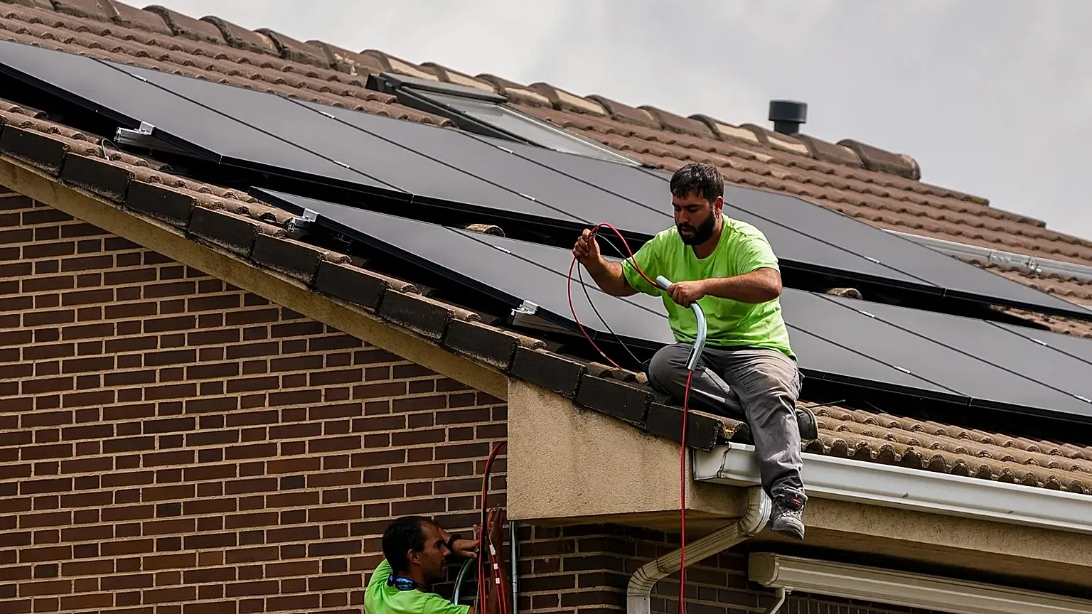 Workers install solar planers on the roof of a house in Rivas Vaciamadrid, Spain.