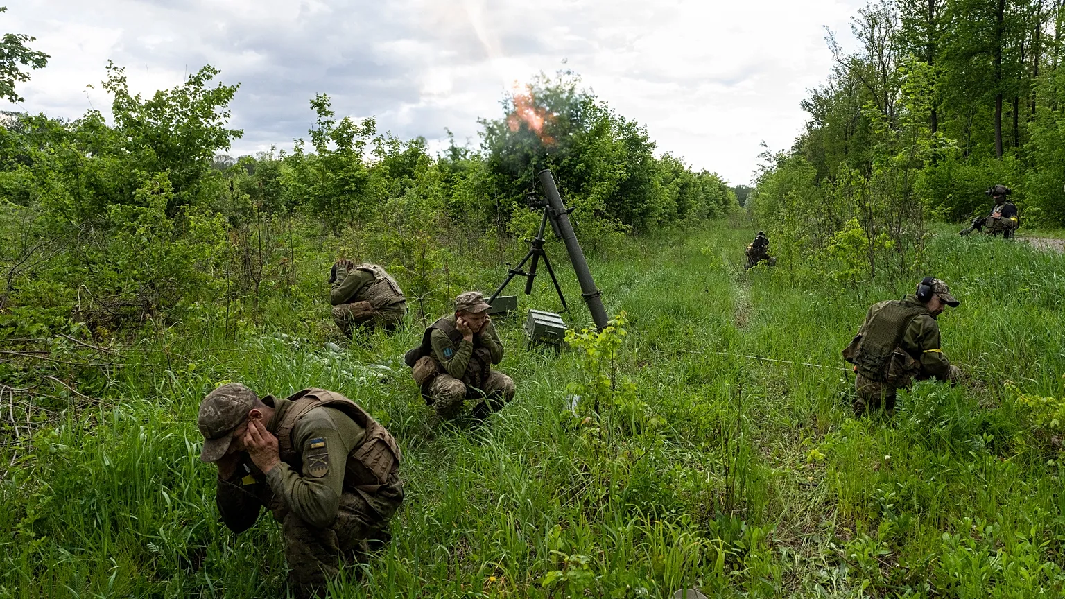 Ukrainian servicemen accompanied by members of the foreign legion fire mortars at Russian positions in the eastern region of Kharkiv, Ukraine, Tuesday, May 17, 2022.