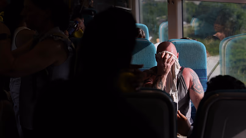 A man on a train wipes sweat from his face on a hot day in London, 24 June, 2026